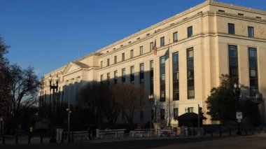 Washington 'daki Capitol Hill' deki Dirksen Senato Ofis Binası. Gün batımında Constitution Avenue 'den görülmüş. Kamera düzgün çalışıyor, insanlar ve araçlar geçiyor..