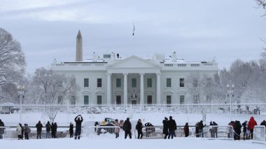 Washington, DC - ABD - 3 Ocak 2022: Beyaz Saray kış fırtınasının ardından karla kaplandı. Turistler Lafayette Meydanı 'ndan izliyor. Gizli Servis ajanları binanın çatısında görüldü..