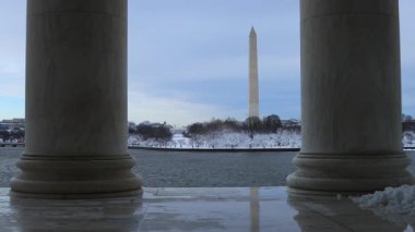 Washington Anıtı ve Beyaz Saray, Jefferson Anıtı 'ndaki iki sütun tarafından çerçevelenmiş gelgit havzasının karşısından görülüyor. Washington 'daki bir kış fırtınasından sonra kar görülebilir.. 