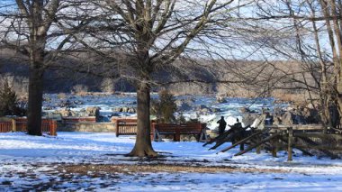 İki ziyaretçi, Virginia, Fairfax County 'deki Great Falls Park' ta bir kış öğleden sonra Potomac Şelalesi 'ne bakar. Kar yerde görüldü..