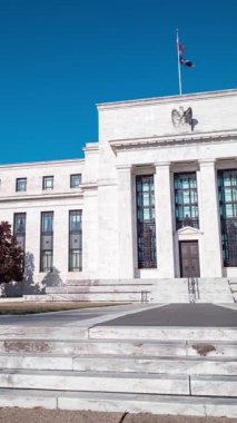 Güneşli bir kış gününde Washington, D.C. 'deki Marriner S. Eccles Federal Rezerv Kurulunun zamanaşımı. Kamera soldan sağa döner. Dikey bileşim.