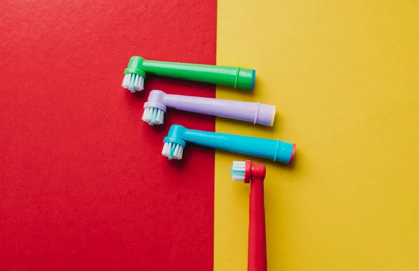 Attachments for an electric toothbrush on a colored background