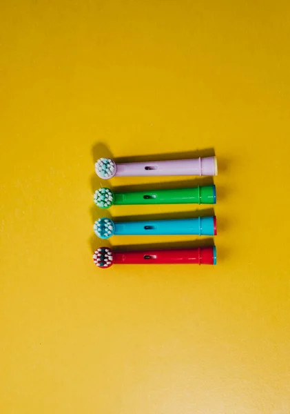Attachments for an electric toothbrush on a colored background