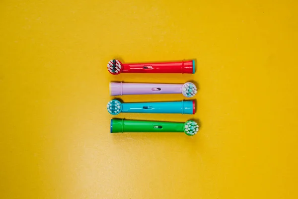 Attachments for an electric toothbrush on a colored background