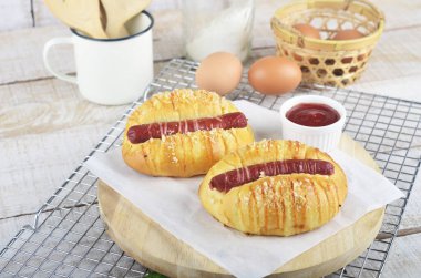 Lezzetli sosisli sandviç ve arka planda malzemeler.