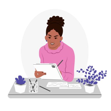 A young smiling African American woman is working on a tablet