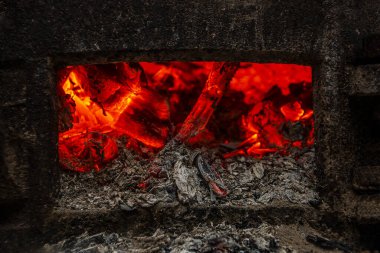 Bir gece şehrinde, ışık saçan ve kafasının üstünde ateş olan bir adamın silueti fenerlerin arka planına karşı çizilmiş.