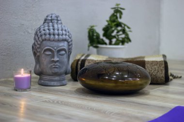 Baş heykelin yanında mum ve yoga dersi için happi dram.
