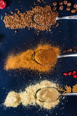 Kahve, hindistan cevizi ve zencefil. Siyah arka planda kaşıklar.