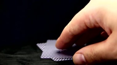 Bir adamın parmakları bir çift ası kaldırır.