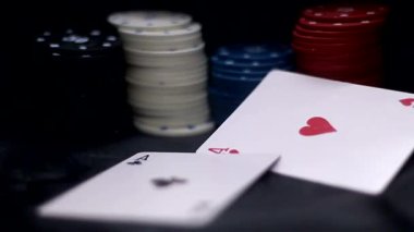 Poker çiplerinin arka planına karşı iki as düşüyor