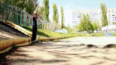 Genç bir adam merdivenlerden stadyumun yamacına atlar.