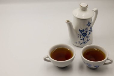 Fincan çay ve beyaz zemin üzerine çaydanlık