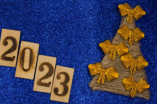 new year 2023, blue background with confetti, stars, golden glitter, tinsel, and christmas decorations,