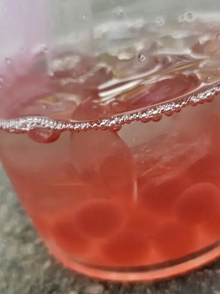 stock image red wine glass with ice cubes