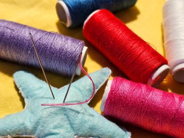 İğneler ve iğnelerle renkli iplik.