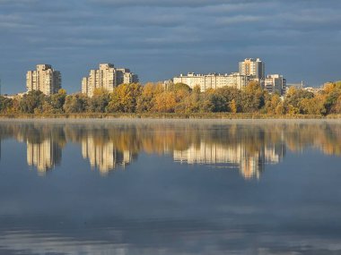 Sonbaharda ağaçlar ve binaların önündeki nehir manzarası