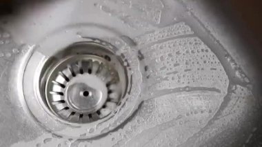 El temizliği metal mutfak lavabosu sabun, sünger ve suyla boşaltılır.
