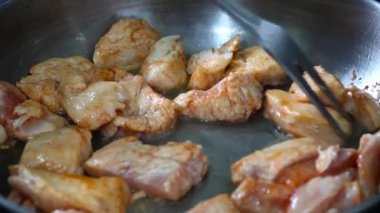 Gümüş çatal kızartma tavasında et pişiriyor.