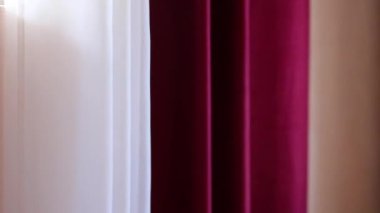 Rüzgarın arka planında hareket eden pembe beyaz pencere perdesi