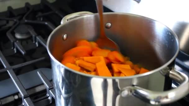 ストーブの鍋でスプーンで野菜をかき混ぜる手 — ストック動画
