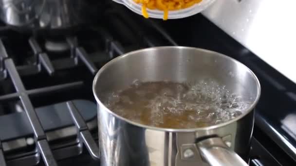 Mãos Adicionando Macarrão Água Quente Panela Fogão Cozinha — Vídeo de Stock