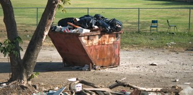Bu büyük metal çöp kutusundaki fazlalık çöplerin fotoğrafı.