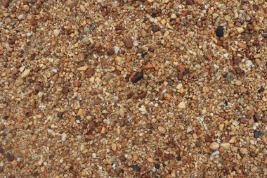 Kuru sarı silis kaya dokusu arka planı. Yuvarlak taş taneleri. Yukarıdan görüntüyü kapat.