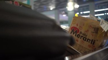 Soekarno Hatta Uluslararası Havalimanı yolcu terminalinin varış noktasındaki bagaj bandında taşınan çeşitli bavullar.