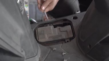 Tangerang, Endonezya - 08 Aralık 2022. Motosiklet tamirhanesine akü monte etmek.