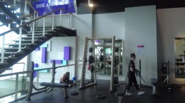 Tangerang, Endonezya - 9 Aralık 2022: Modern spor salonundaki faaliyetlerin zamanlaması. Egzersiz yapan insanlar.