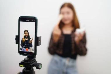 Asyalı kadın vlogcu IG 'nin ana stüdyosunda canlı yayında kendini nasıl toparlayacağını göstermeye hazırlanıyor. Z jenerasyonu viral video yakalama uygulamaları çekiyor..