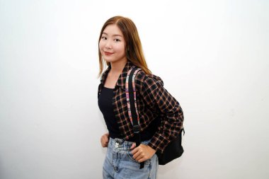 Sırt çantası izole edilmiş beyaz arka planı olan gülümseyen Asyalı genç bir öğrencinin portresi..