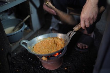 Satıcı, kömür ocağı olan küçük bir tavada yumurta kabuğu veya kerak telor pişiriyor. Kerak Telor, ördek yumurtasıyla hindistan cevizi rendelenmiş pirinç karıştırılmış geleneksel bir jakarta yemeğidir..