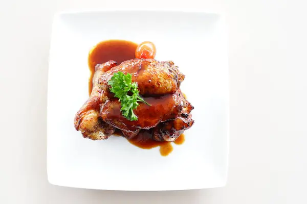 stock image A close-up photo of a plate overflowing with Korean fried chicken wings. The wings are glazed in a glossy red sauce and sprinkled with white sesame seeds. High quality photo