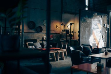 Denpasar, Ağustos 2021. Görüntü modern ve endüstriyel bir kafe ya da dinlenme odasını betimliyor. Alan, açık tuğla duvarlar, büyük pencereler ve yüksek tavanlar ile karakterize edilir.. 