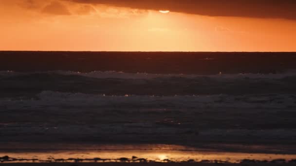 Eldröd Solnedgång Ovanför Det Stormiga Havet Sandstranden Ligger Förgrunden Slow — Stockvideo