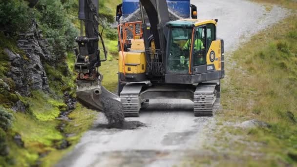 Excavator Repairing Unpaved Road Slow Motion Pan Follow High Quality — Stockvideo