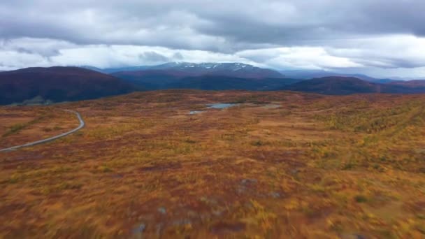 カラフルな秋のツンドラの風景の空中ビュー 空に重い雲 地平線の山の塔 前にパン 高品質4K映像 — ストック動画
