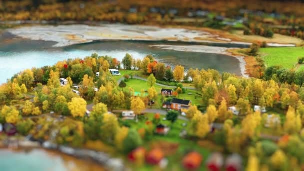 キャンプ場とフィヨルドの海岸にある旧サミ漁村の小さな景色 キャビン テント ボートハウスは秋の木々の間に散在しています 空中ビュー — ストック動画