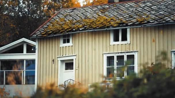 北ノルウェーの秋の風景の中に石瓦の屋根を持つカントリーハウス ポーチに白いベンチが立っている スローモーション パンを残しました 高品質4K映像 — ストック動画