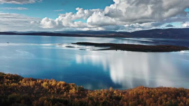 フィヨルドの鏡のような水に囲まれた小さな島 上の白い雲 秋の森は海岸を覆う 背景には山の塔 高品質4K映像 — ストック動画