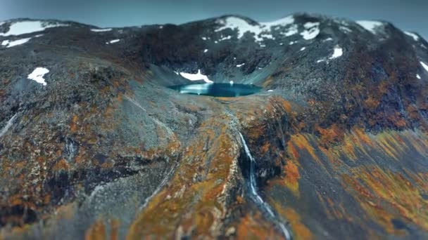 古代の火口内の高山湖 山頂には新雪が 滝は山の中腹にレース 空中ビュー スローモーション パンを残しました 高品質4K映像 — ストック動画