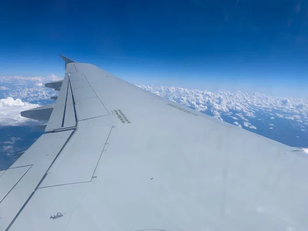 Travel by plane, view from plane window to wing, plane and outward view