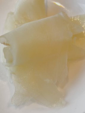 Gari, beyaz kasede zencefil turşusu. İnce dilimlenmiş zencefil, şeker ve sirkeyle marine edilmiş, suşiden sonra servis edilmiş. Geleneksel olarak hazırlanmış renk soluk sarı ya da pembedir. Yukarıdaki yemek fotoğrafından yakın çekim.