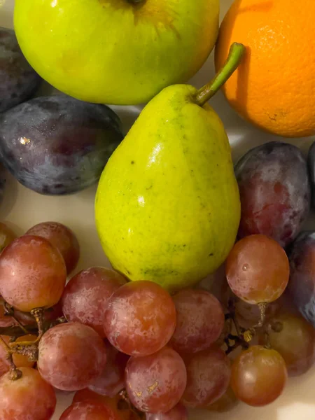 Fruchtzusammensetzung Auf Einem Teller Birne Traube Pflaume Orange — Stockfoto