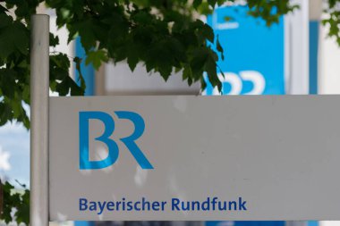 Münih, Almanya - 14 Haziran 2025: Yapraklarla çerçevelenmiş Bayerischer Rundfunk (BR) için beyaz arkaplanda mavi logo işareti.