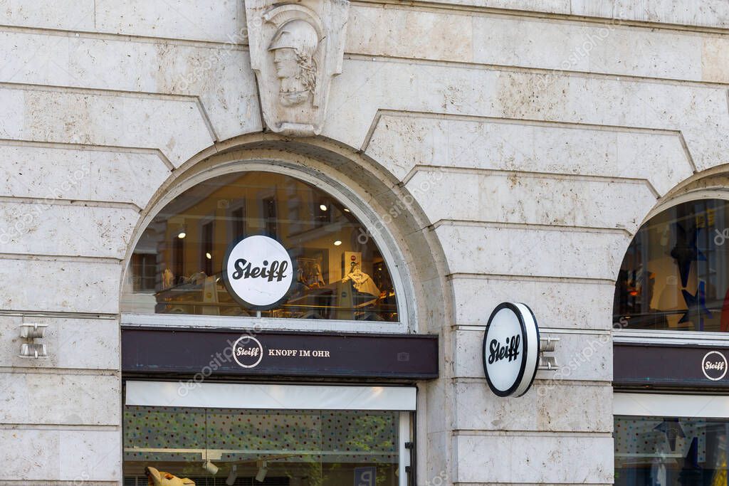 Munich, Germany - June 14 2025: Exterior view of a Steiff store featuring arched windows, stone facade, and prominent Steiff logos.