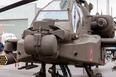 Nuremberg, Almanya - 25 Mayıs 2025: Apaçi helikopterine yakın çekim, diğer hava araçlarıyla bulanık bir arka plana karşı silahlarını, kokpitini ve iniş takımlarını sergiliyor.