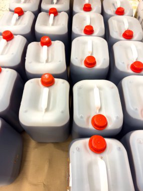 Nuremberg, Almanya, 14 Aralık 2024: Koyu sıvı ile dolu kırmızı kapaklı kare plastik konteynırlar. Her konteynırın beyaz kulpları.